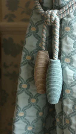 Blue patterned curtain fabric tied with two long woven tassels