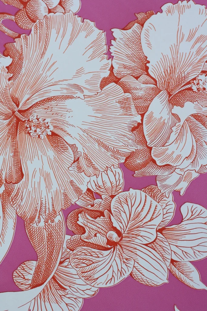 Close detail of a large white floral wallpaper pattern on a raspberry ground
