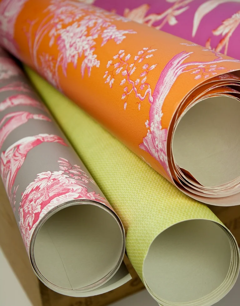 Rolled wallpaper in orange, lime and floral pink patterns
